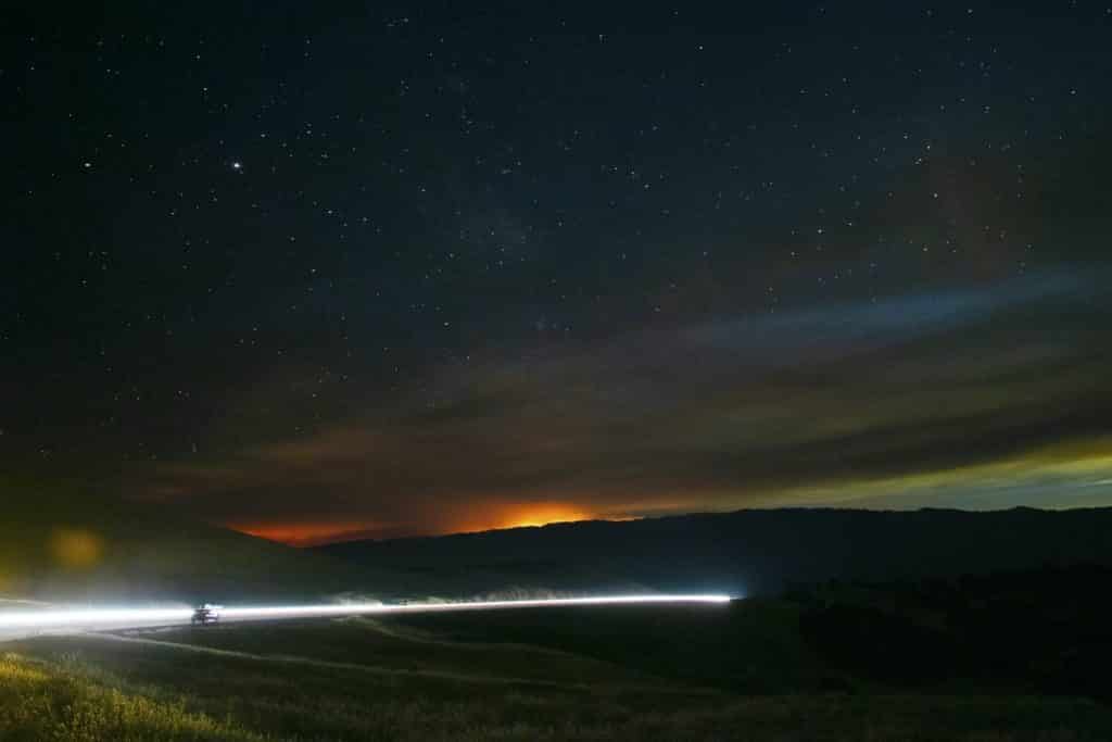 The SCU Lightning Complex fire’s glow under a starry night sky over the hills and mountains of Del Valle Regional Park near Livermore, California.