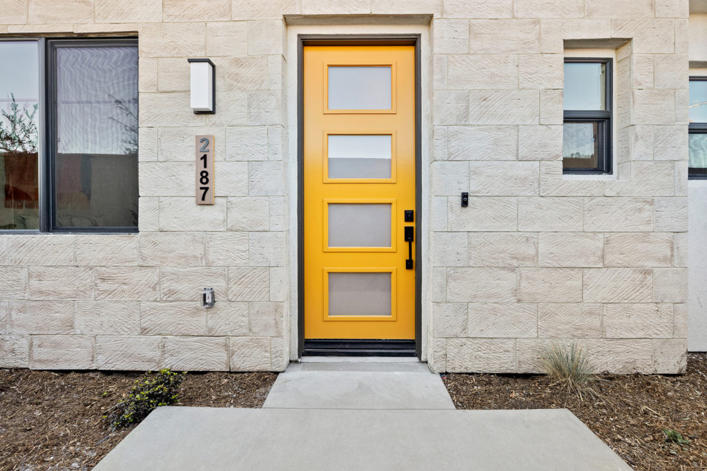8 foot yellow door at the entrance to the gardenia smart home