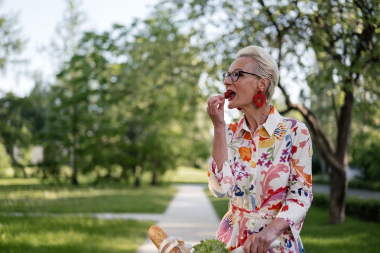 A California senior woman enjoying eating a strawberry