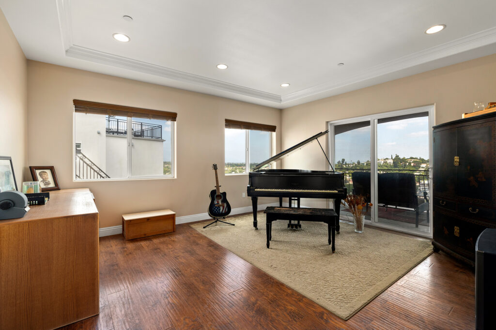 Inside of the home the music room is spacious showcasing a grand piano with large windows with natural light and sweeping views. Tour this great El Sereno Home!