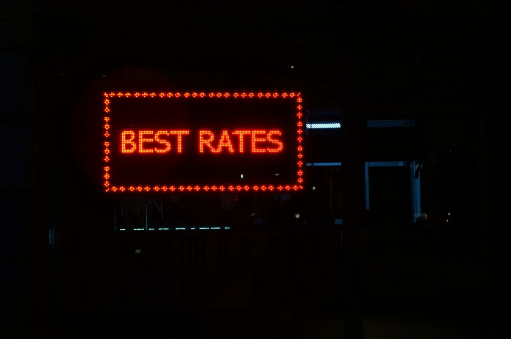 Photo by Jon Cellier of a neon red sign that says Best rates on a rooftop of a building in a city on Unsplash First Time Home Buyers