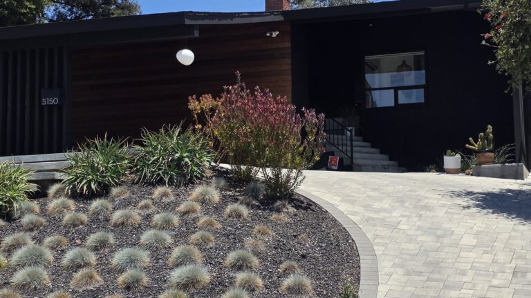 Black mid-century home with a landscaped driveway in Mt. Washington