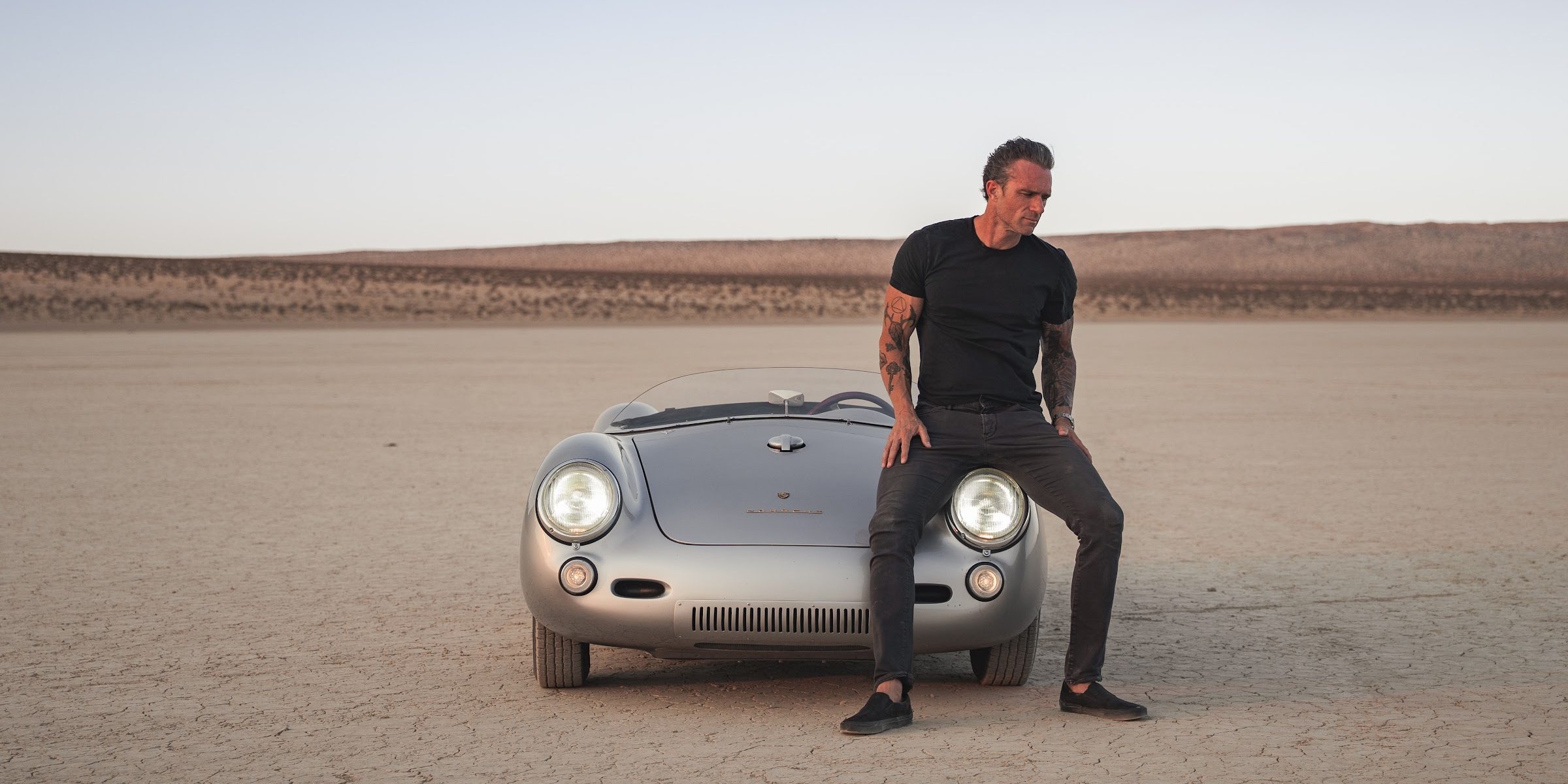 Glenn Shelhamer, Los Angeles real estate broker, with a Porsche 550 Spyder on a dry lake bed